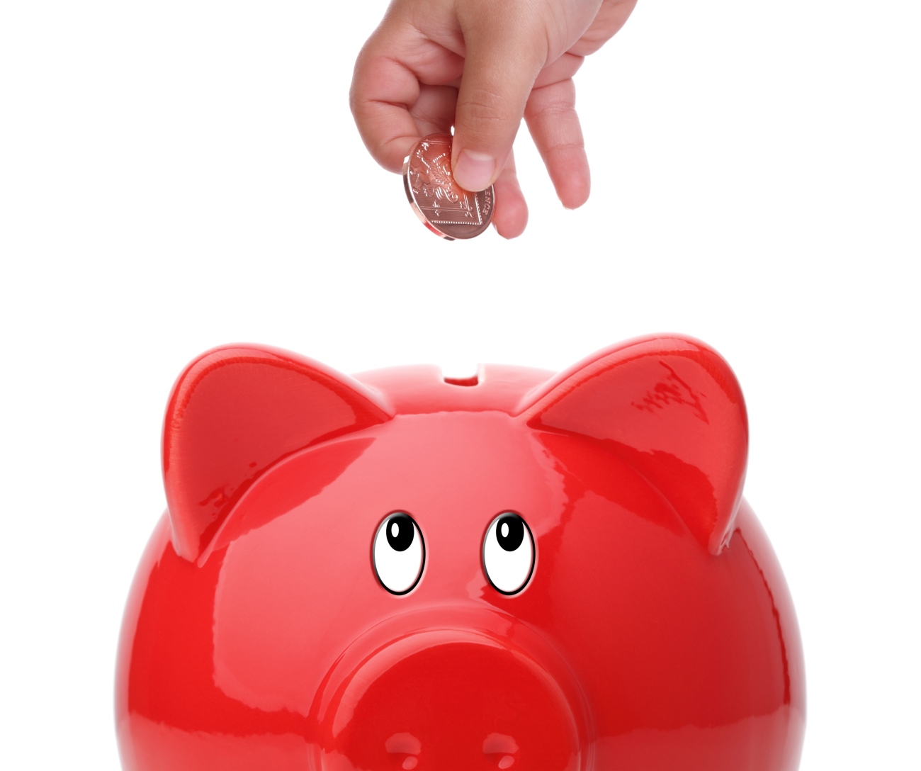 Hand, die eine Münze in ein rotes Sparschwein in Form eines Schweins wirft