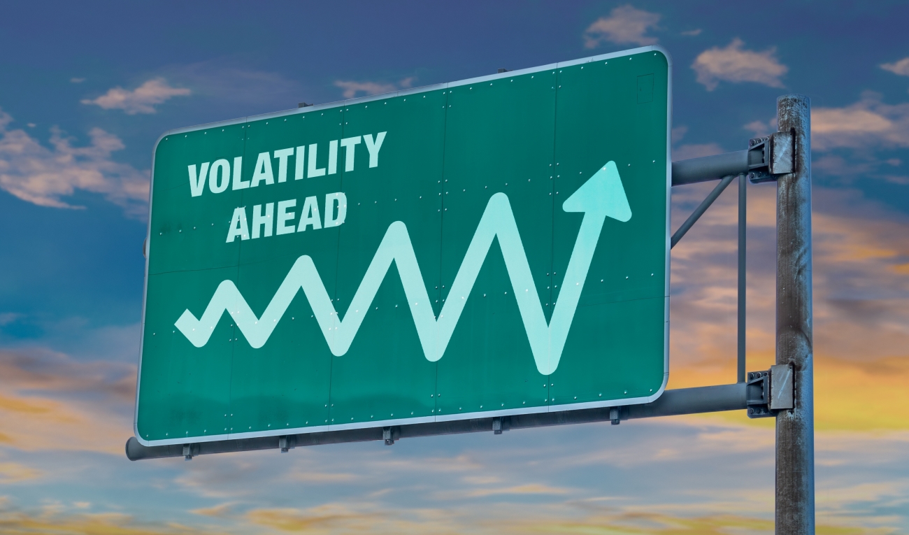 Cartello autostradale verde con la scritta volatility ahead e una freccia ondulante