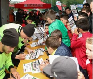 Giocatori dell'FC Sudtirol che fanno autografi ai bambini