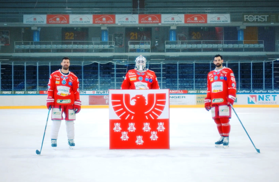 3 giocatori di hockey del Bolzano Foxes con davanti il logo Sparkasse