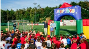 Tanti bambini seduti su un campo da calcio