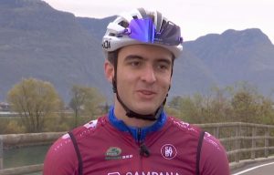 Matteo Bianchi con casco da bici bianco, occhiali da corsa e tuta colore bordeaux